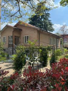 a brick house with a balcony in a garden at B&B Borgo dei Cedri in Pontecchio