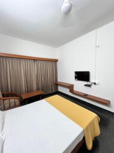 a bedroom with a large bed and a tv at MRP Residency in Chitradurga +16 photos