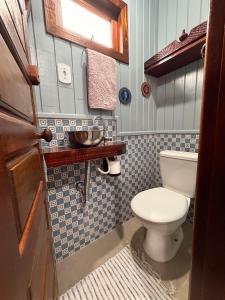 a small bathroom with a toilet and a sink at Pousada Nó de Pinho - Kitnet Microcasa in São Joaquim