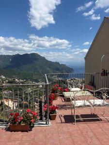 a balcony with tables and chairs and flowers at Guest House Malù in Scala