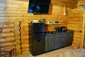 a kitchen in a log cabin with a refrigerator at Cottages Vakhrama in Abastumani