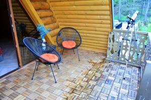three chairs sitting on a patio with a camera at Cottages Vakhrama in Abastumani +7 photos
