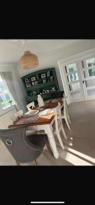 a dining room with a table and two windows at Glenmore in Doonbeg