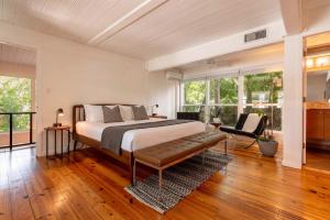 a bedroom with a bed and a chair and windows at TreeTops Spacious Architectural Retreat in Gainesville