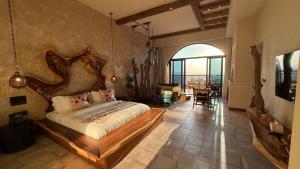 ein Schlafzimmer mit einem großen Bett mit hölzernem Kopfteil in der Unterkunft Tal Rumman Boutique Hotel in Gerasa + 235 Fotos