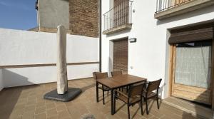 a table and chairs on a balcony with a pole at Plaza Apartamentos in Binéfar