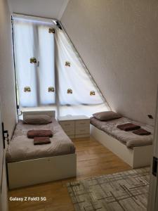 a bedroom with two beds and a window at Shabran Pearl A-Frame in Surra +17 photos