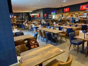 a restaurant with wooden tables and chairs and a bar at The James Lodge in Little Clacton