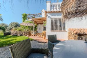 a patio with a table and chairs and a house at La Casa del Burro in Nerja
