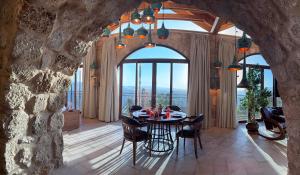 ein Esszimmer mit einem Tisch und einer Steinwand in der Unterkunft Tal Rumman Boutique Hotel in Gerasa