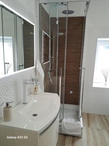 a white bathroom with a shower and a sink at Kuća Get in Betina +34 photos