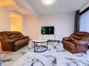 a living room with two leather chairs and a tv at Villa vista mare in Zagrađe