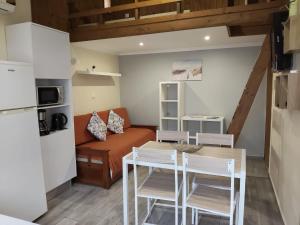 a kitchen and living room with a table and chairs at Casa Verão Azul in Monte Gordo