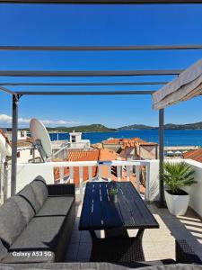 a patio with a couch and a table on a balcony at Kuća Get in Betina