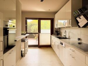 a kitchen with white cabinets and a large window at TheSlowMorningNo1 in Cuxhaven +33 photos