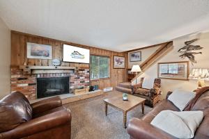 a living room with leather furniture and a fireplace at Trapper 8: Cozy 4-Bedroom Condo, 1 Minute to Yellowstone, perfect for 8 guests. in Levokumskoye