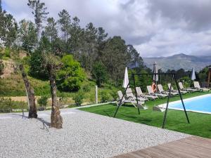 a group of lounge chairs and a swimming pool at Quinta Cunha in São Pedro do Sul
