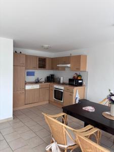 a kitchen with wooden cabinets and a table with chairs at Strandkorb 115 in Rostock