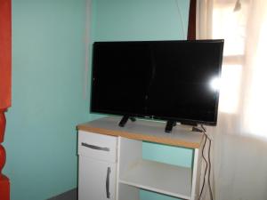 a flat screen tv sitting on top of a white cabinet at Hospedaje Las Tinajas in Molinos