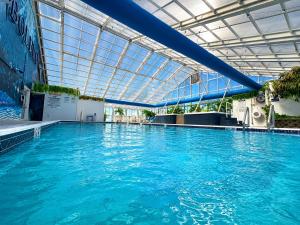 a large swimming pool with blue water in a building at Bolero Resort in Wildwood