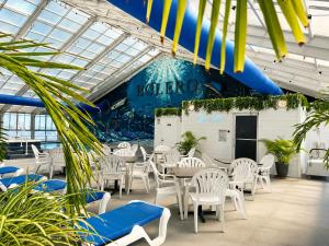 a restaurant with white chairs and tables in a building at Bolero Resort in Wildwood