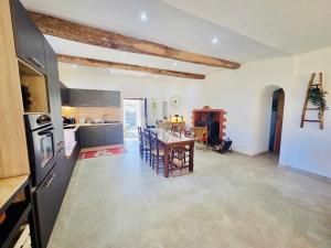 a kitchen and living room with a table and chairs at Mas des châtaigniers in Le Vigan