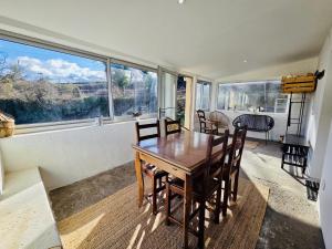 a dining room with a table and chairs and a large window at Mas des châtaigniers in Le Vigan +25 photos