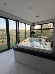 a large bath tub in a room with windows at Woodroyd Spa Suites in Luddenden Foot
