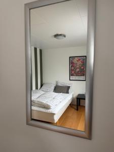 a mirror reflecting a bed in a bedroom at Kystvejen 40F in Hadsund