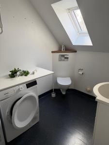 a white bathroom with a toilet and a sink at Kystvejen 40F in Hadsund +7 photos