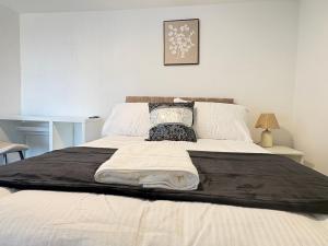 a bed with a black blanket on top of it at Seaside Apartments Redcar in Redcar