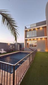 a house with a swimming pool in front of it at شاليه لافندر ينبع in Yanbu Al Bahr
