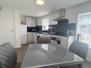 a kitchen with a table and chairs in a room at Seaside Apartments Redcar in Redcar +28 photos