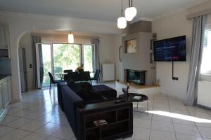 a living room with a couch and a tv at Ionian Juliet Villas in Kothoníkion +25 photos