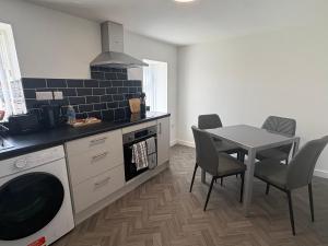 a kitchen with a table and a stove and a microwave at Seaside Apartments Redcar in Redcar