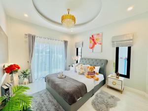 a bedroom with a teddy bear sitting on a bed at บ้านแสนสุข Hun Hin in Hua Hin