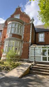 a large brick house with a staircase in front of it at Apex Rooms Salford - Free Parking in Manchester