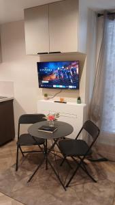 a table and chairs in a living room with a tv at Luxury Studio - Romainville in Romainville
