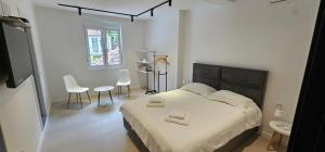 a bedroom with a bed and two chairs and a window at Apartments Grgurević in Kotor