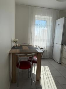 a kitchen with a table and chairs and a refrigerator at NV Apartments in Volodymyr-Volynskyi +2 photos