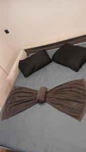 a bed with a large brown bow tie on it at Luxury Studio - Romainville in Romainville