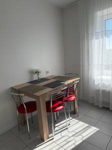 a wooden table with red chairs in a room at NV Apartments in Volodymyr-Volynskyi