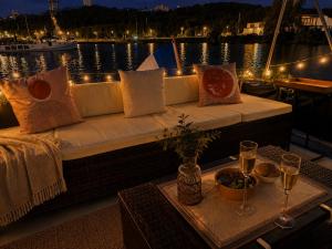 a couch on a boat with a table with wine glasses at Zimon- Bateau Authentique - vue sur la Seine in Rouen