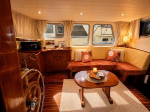 a living room with a couch and a table at Zimon- Bateau Authentique - vue sur la Seine in Rouen