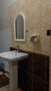 a bathroom with a sink and a mirror on the wall at شقق عناوين الفخامة in Şāmitah