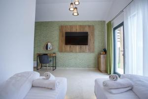 a living room with two white couches and a television at Danube Delta Bungalows Gorgova in Gorgova +50 photos