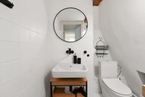 a white bathroom with a sink and a mirror at TINY HOUSE Old Town in Prague +33 photos