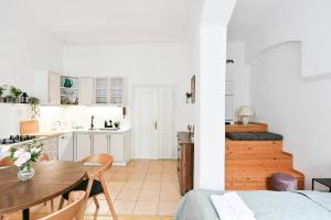 a kitchen and dining room with a table and a kitchen with white cabinets at TINY HOUSE Old Town in Prague