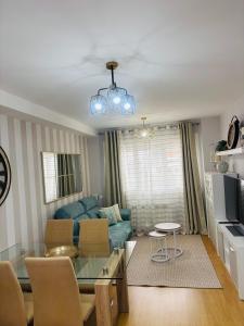 a living room with a blue couch and a table at Maresia in Burela de Cabo