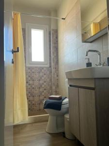 a bathroom with a toilet and a sink and a window at Kleopatra's Apartments in Chios +40 photos